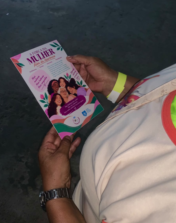 Mulher segurando a cartilha sobre a Força da Mulher Além da Aparência